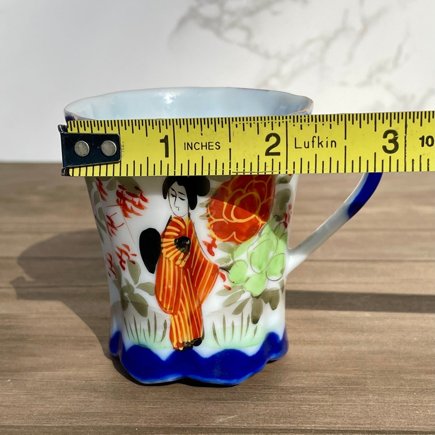 vintage sake tea cup with geisha and flowers hand painted japanese blue rimmed scalloped edge cup made in japan tall and selnder cup geisha girl in red dress red flowers gold embellishments green plants japanese landscape hand painted imagewhite porcelain scalloped base tea cup sake cup vintage gift asain inspired asain kitchen asain cup asain home decor thebrokenbirdcompany free shipping