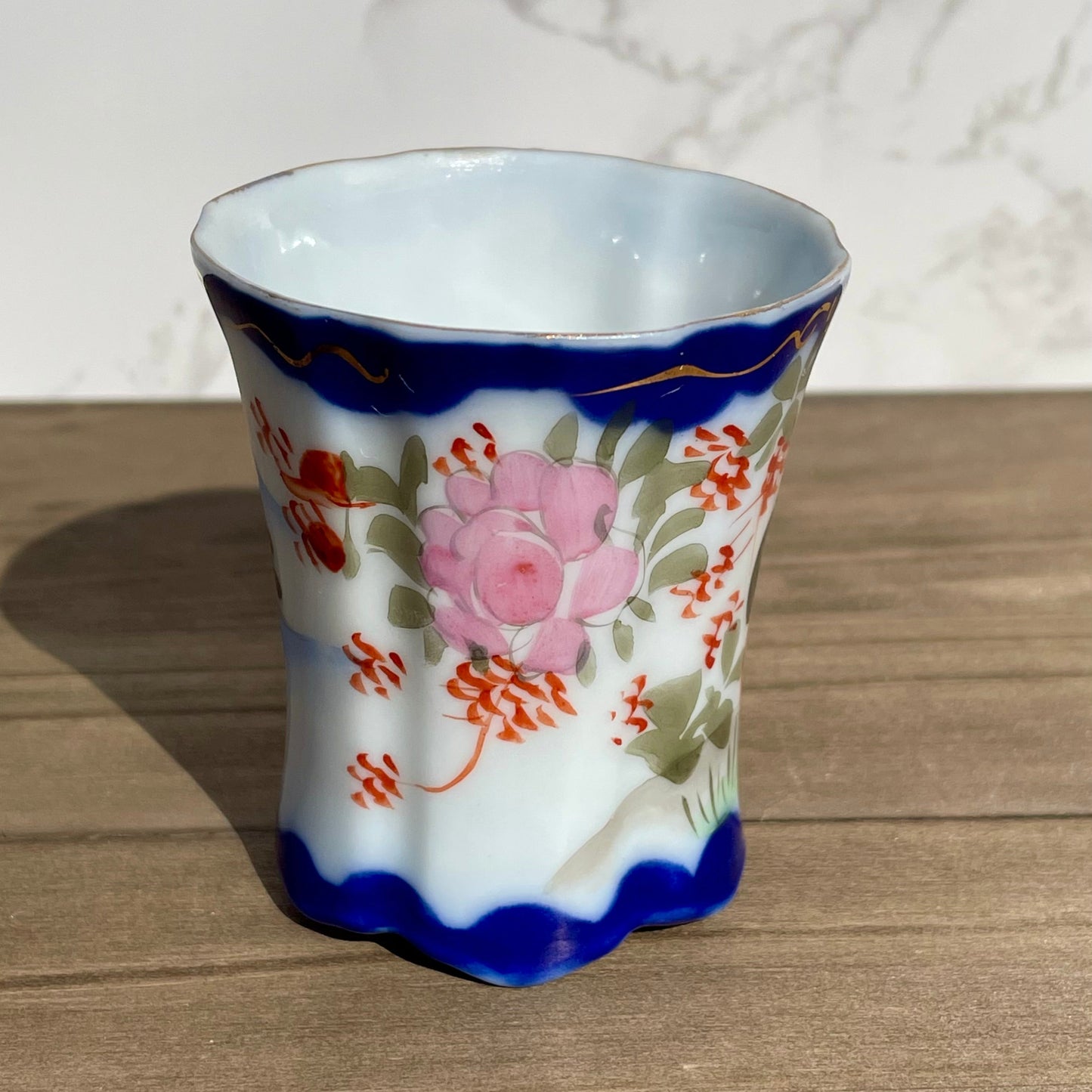 vintage sake tea cup with geisha and flowers hand painted japanese blue rimmed scalloped edge cup made in japan tall and selnder cup geisha girl in red dress red flowers gold embellishments green plants japanese landscape hand painted imagewhite porcelain scalloped base tea cup sake cup vintage gift asain inspired asain kitchen asain cup asain home decor thebrokenbirdcompany free shipping