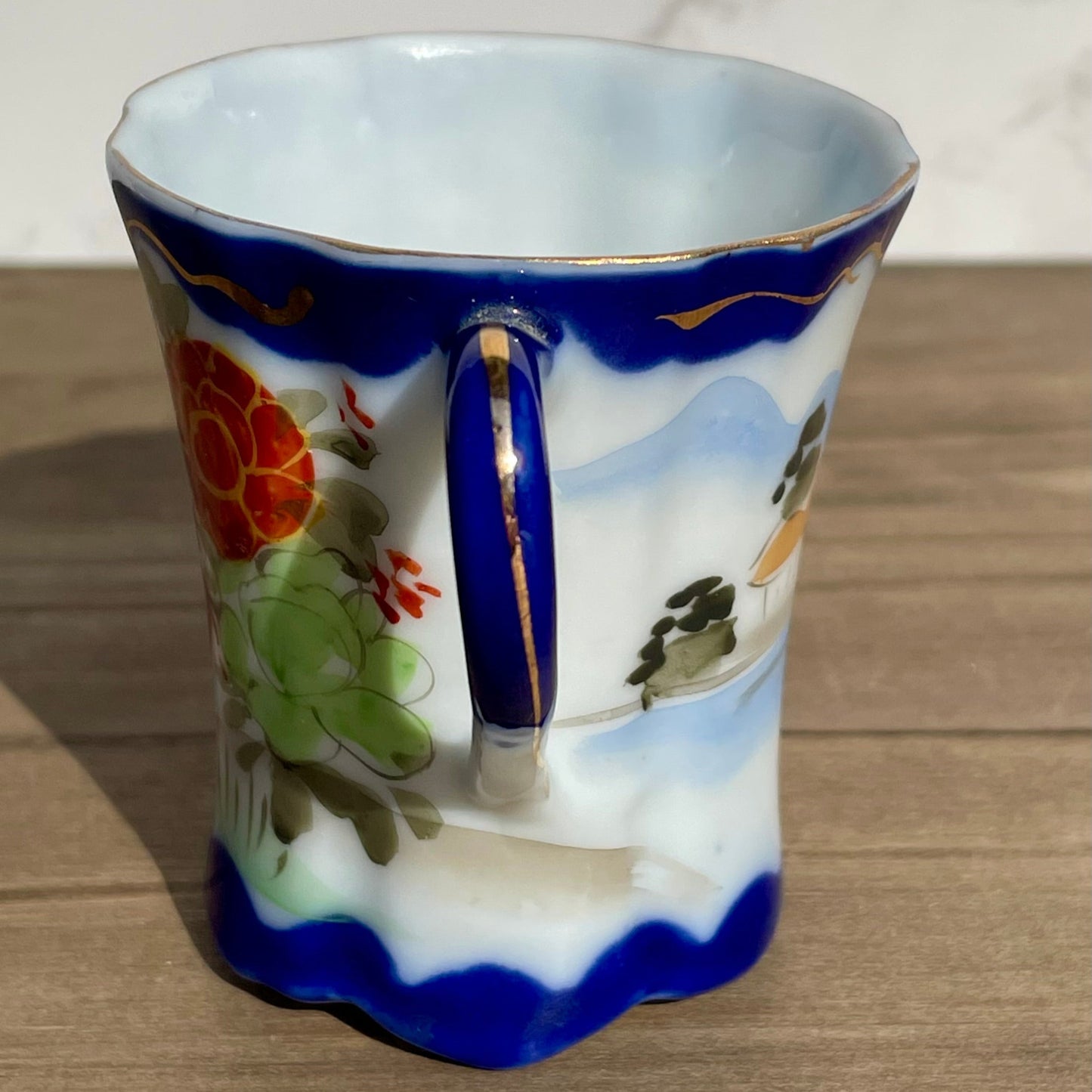 vintage sake tea cup with geisha and flowers hand painted japanese blue rimmed scalloped edge cup made in japan tall and selnder cup geisha girl in red dress red flowers gold embellishments green plants japanese landscape hand painted imagewhite porcelain scalloped base tea cup sake cup vintage gift asain inspired asain kitchen asain cup asain home decor thebrokenbirdcompany free shipping