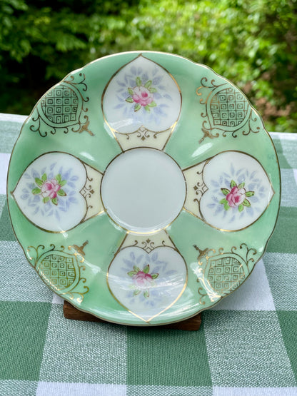 Decorative ceramic plate with floral patterns on a green checkered tablecloth