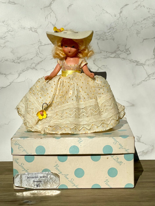 Nancy Ann storybook doll season series 91 summer doll antique collector doll yellow dress blonde hair yellow flower on hat original box frozen legs free shipping antique gift collector gift thebrokenbirdcompany christmas birthday gift for her mothers day 1940s collector doll cream colored box with blue polka dots