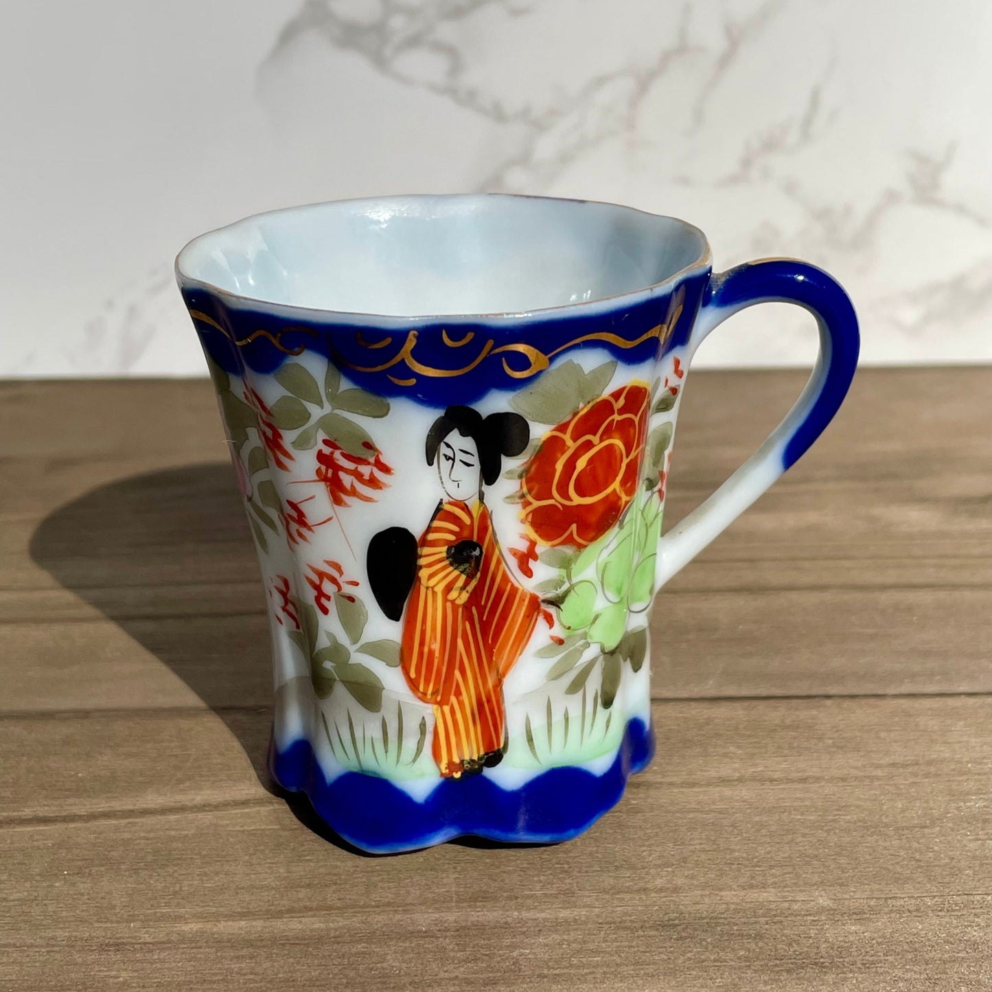 vintage sake tea cup with geisha and flowers hand painted japanese blue rimmed scalloped edge cup made in japan tall and selnder cup geisha girl in red dress red flowers gold embellishments green plants japanese landscape hand painted imagewhite porcelain scalloped base tea cup sake cup vintage gift asain inspired asain kitchen asain cup asain home decor thebrokenbirdcompany free shipping 