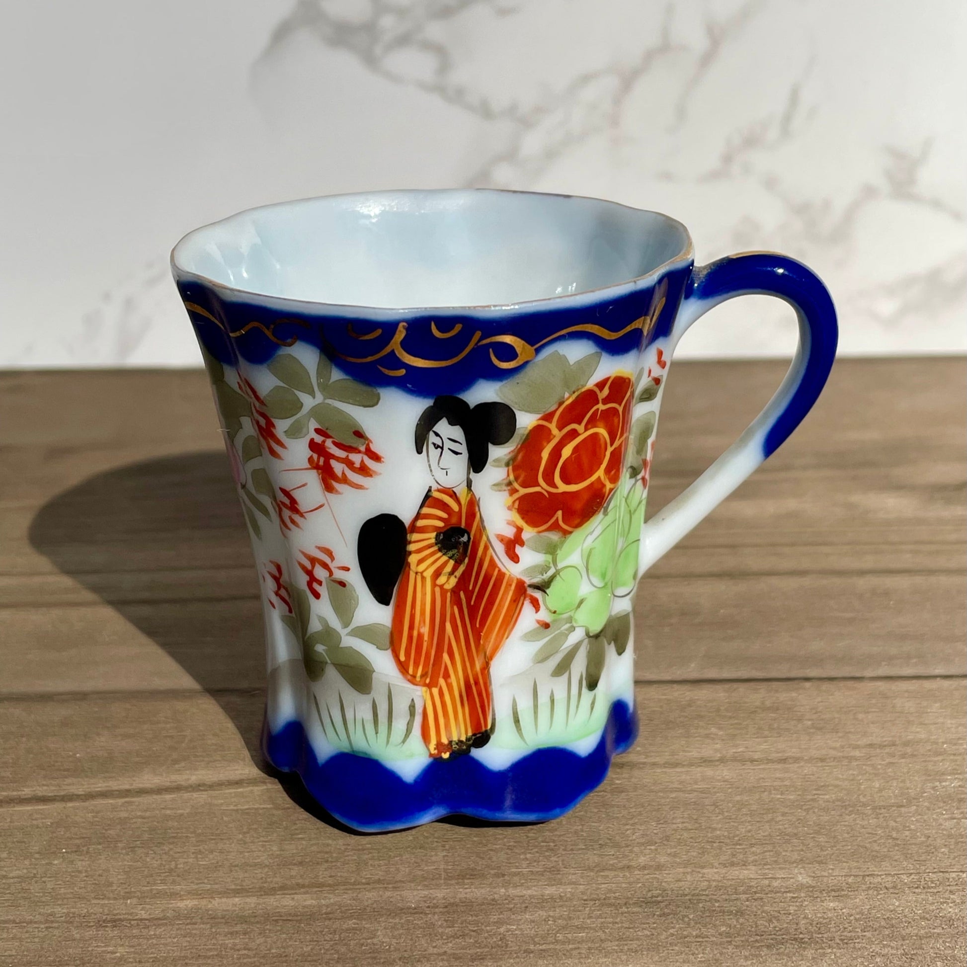 vintage sake tea cup with geisha and flowers hand painted japanese blue rimmed scalloped edge cup made in japan tall and selnder cup geisha girl in red dress red flowers gold embellishments green plants japanese landscape hand painted imagewhite porcelain scalloped base tea cup sake cup vintage gift asain inspired asain kitchen asain cup asain home decor thebrokenbirdcompany free shipping 