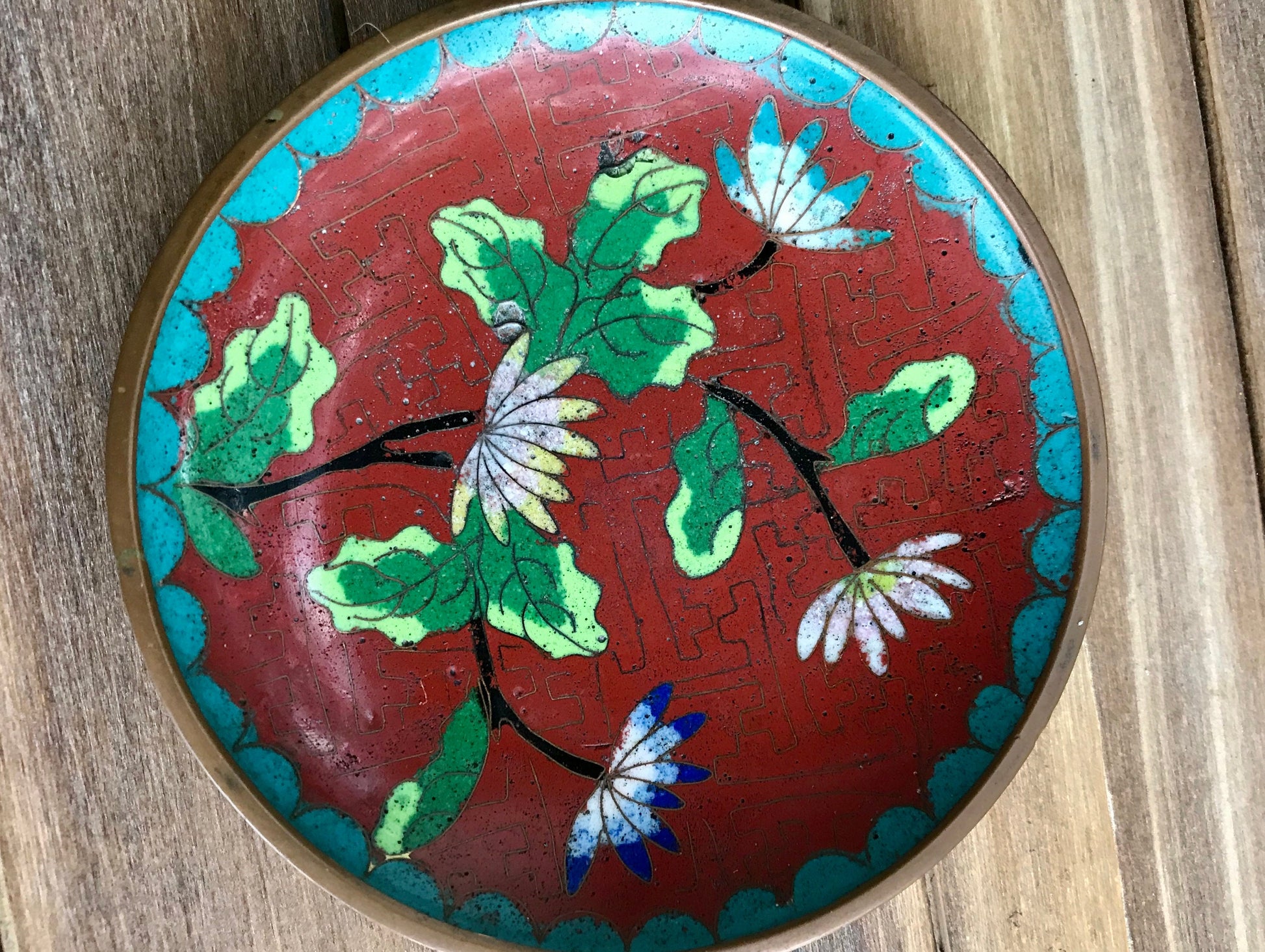 Beautiful rare antique Chinese Cloisonné red enamel on bronze plate with intricate etching lotus flowers and geometric shape trim in turquoise or Jingtai blue with geometric design in red. Lotus flowers in Chinese art represent purity, enlightenment and rebirth in Buddhist iconography. This is extremely rare piece due to the CHINA stamping on the back and the A being a triangle. Most likely from 1912-1949.